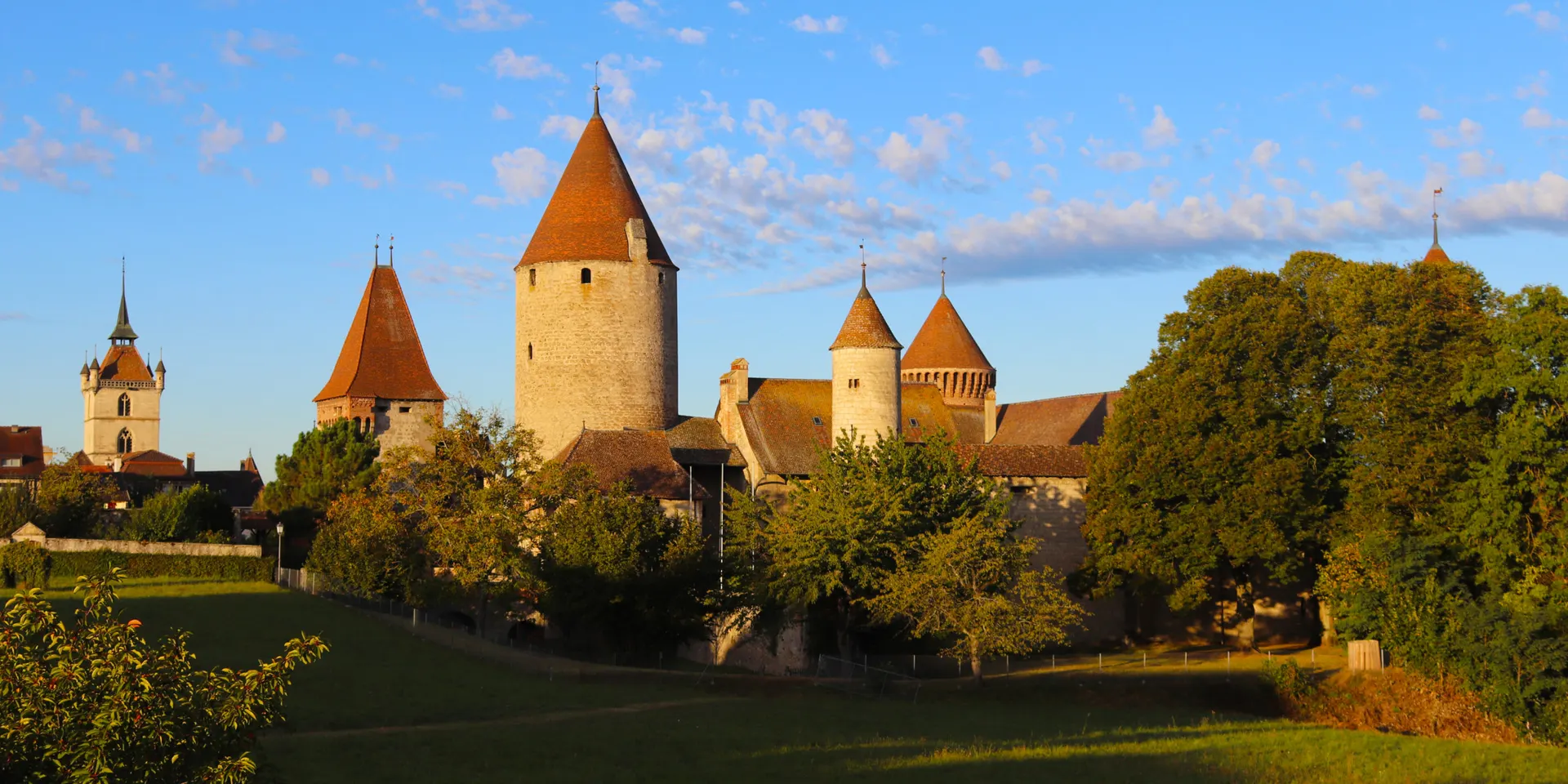 Le château de Chenaux dans une lumière dorée, au-dessus du Pré du Château